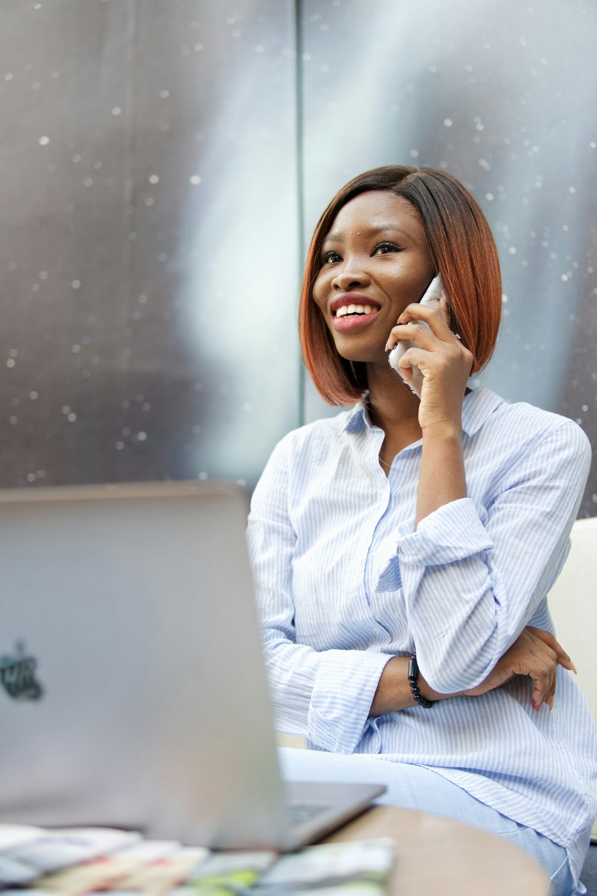 Woman smiling while taking a phone call at her desk